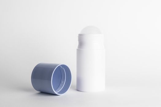 Roll-on antiperspirant cosmetic and blue cover isolated on white background