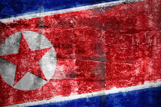 Grungy Flag of North Korea on stone texture background closeup