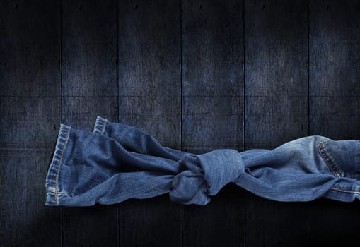 Jeans knot on dark blue wooden background. Clipping Path