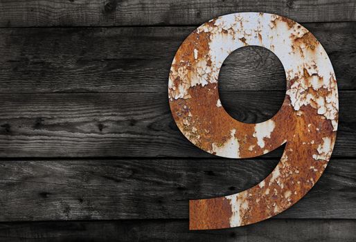 Old rusty metal alphabet, text 6 on Wooden Background nails.