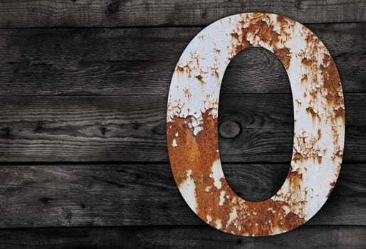 Old rusty metal alphabet, text 0 on Wooden Background nails.