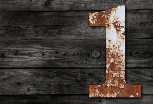 Old rusty metal alphabet, text 1 on Wooden Background nails.