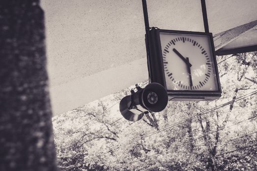 An old railway station clock in Warsaw Poland. In sepia tone color.