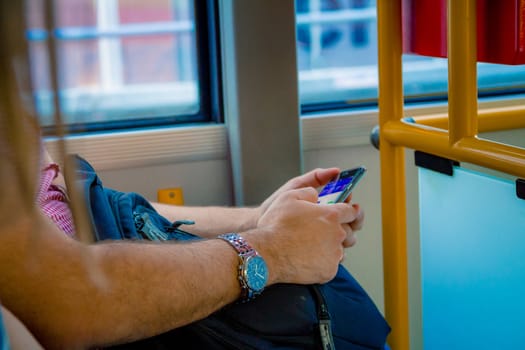 Close up on a man using a smartphone while he is traveling by bus in Warsaw Poland.