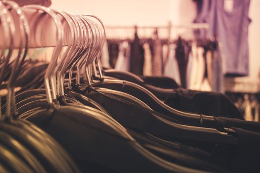 Close up of many clothes on hangers in a clothing shop.