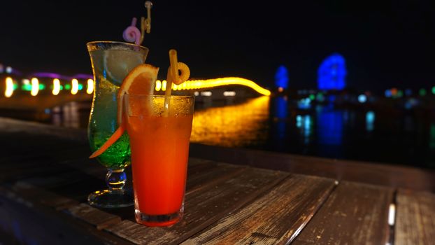 Exotic summer drinks, against blur night city view background