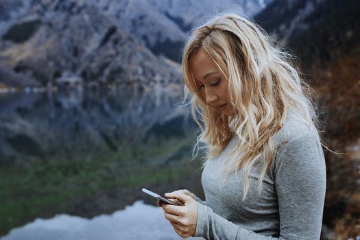 Woman using smartphone at the lake