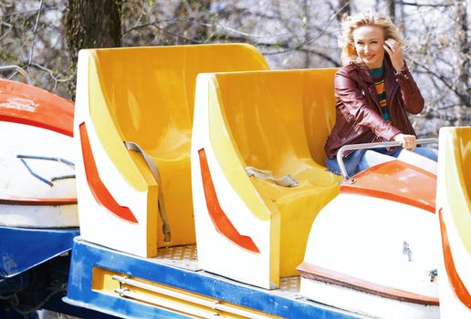 Blond woman having fun and riding on a rollercoaster