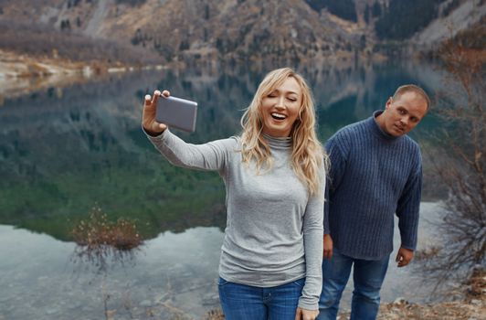 Couple making selfie at the mountain lake