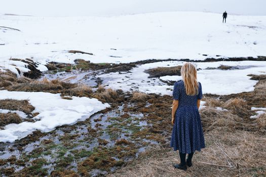 Woman and man in the winter landscape with marshy puddle