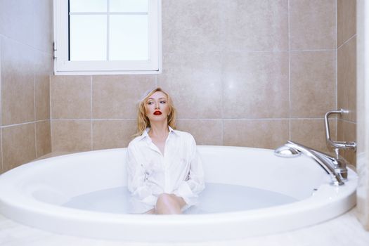 Woman wearing white shirt relaxing in the bath