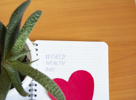 Medical concept, Flatley, world health day, text on Notepad, heart shape on wooden table.