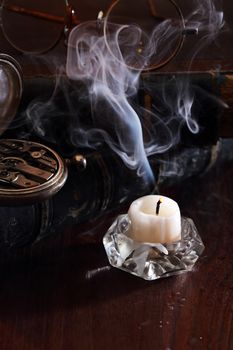 Vintage still life with watch and spectacles on old books near candle