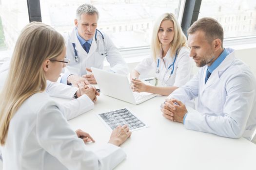 Team of doctors working in the office discussing brain MRI scan