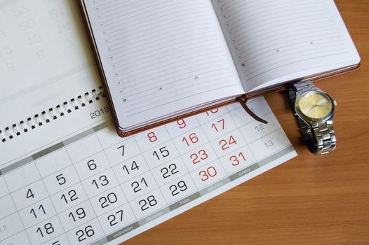 Workplace for men businessman with a clock, calendar and organizer on a wooden table.