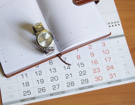 Workplace for men businessman with a clock, calendar and organizer on a wooden table.