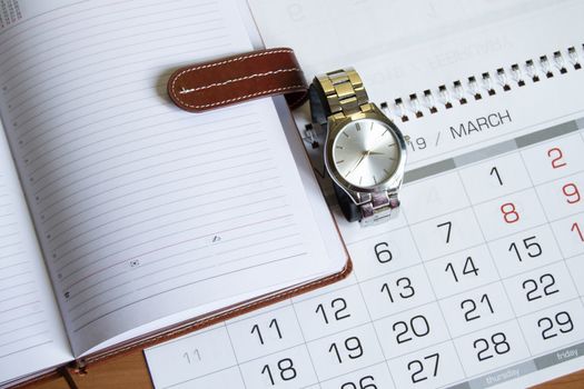 Workplace for men businessman with a clock, calendar and organizer on a wooden table.