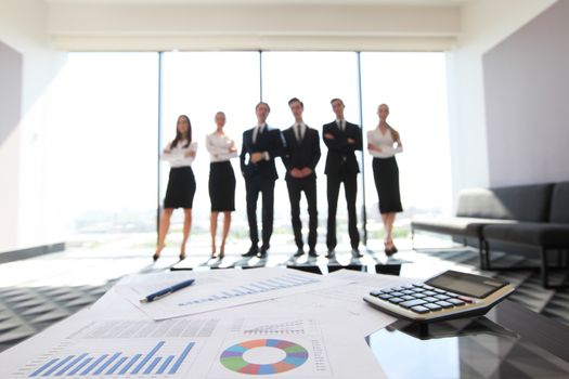 Close up view of printed graphs and business people discussing financial data