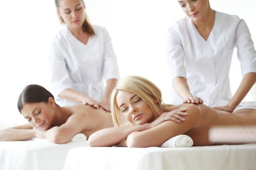 Two beautiful women getting massage in spa