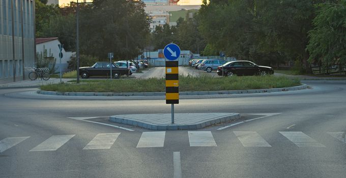 Crossroad with traffic sign and parking lot in background