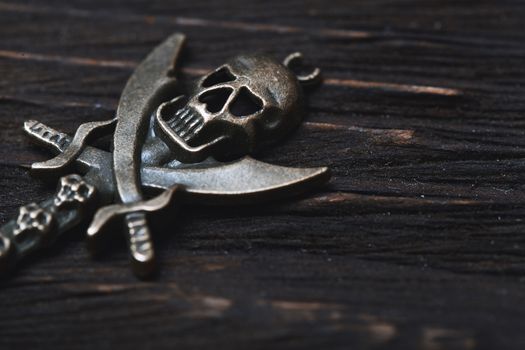 Vintage skull and pirate key on a wooden table. Close-up view
