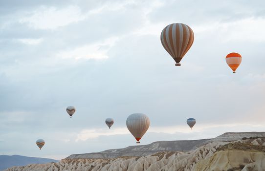Hot air balloons flying over the rocks of Cappadocia, Turkey