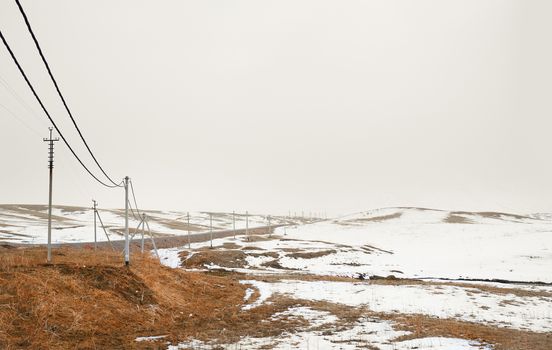 Winter field with power line columns