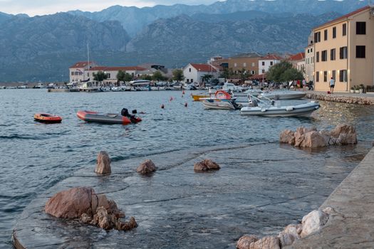 Traditional old village Vinjerac, Croatia, Velebit mountains and Paklenica national park in background, dramatic sky clouds, harbor and waterfront in the evening