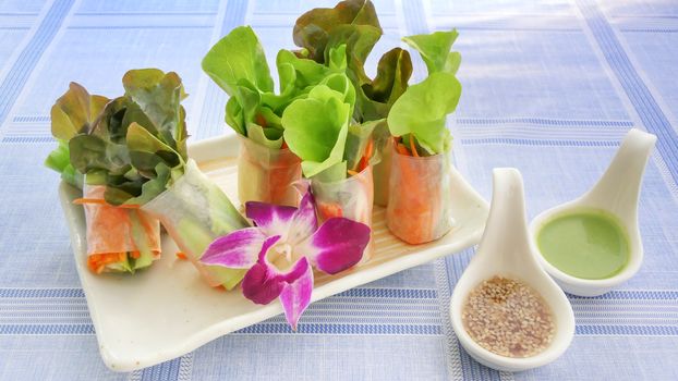 Fresh vegetable salad roll in noodle tube with crab stick on dish