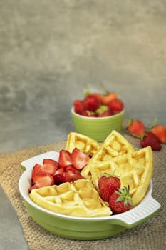 Waffles with fresh ripe red strawberries served on a plate