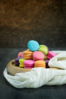 colorful of macarons on plate over wooden table