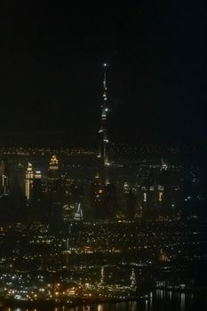 Skyline of Dubai UAE Burj Khalifa in the dark as seen from an airplane