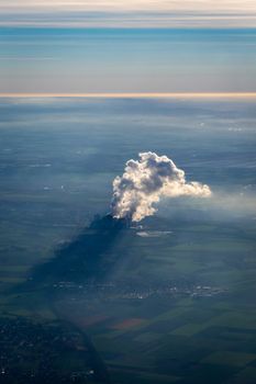 Smoke and steam of a power plant with shadow on the ground in Germany