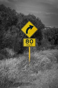 Street sign in Australia warning right curve ahead speed 80 in black and white with yellow accent color