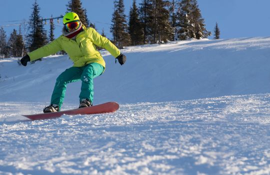 Female snowboarder on slope in the sunny morning , copy space for text