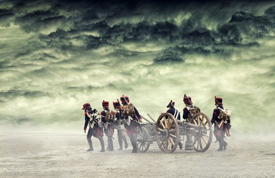 Napoleon soldiers marching in open land with a cannon.