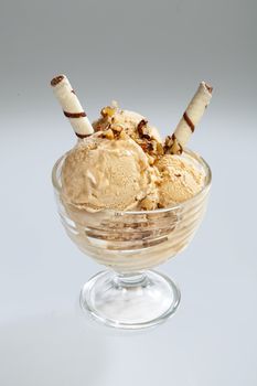 Glass with icecream and cookies on a studio background