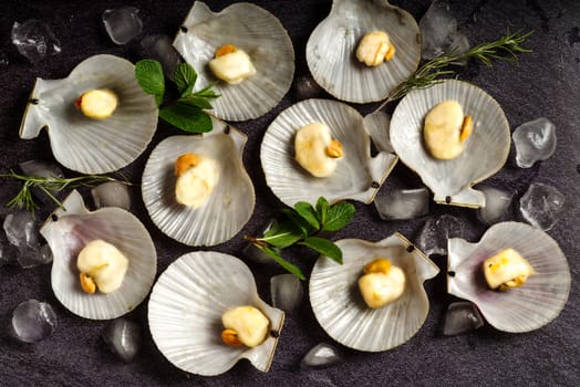 Delicacies. Fresh scallops on a black stone plate