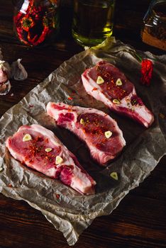 Raw Steaks with Chili Pepper and Garlic. Vertical Orientation.