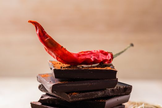 Dry red chili peppers on chocolate bars with cayenne powder.