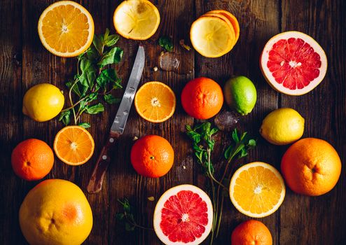 Citrus Fruits Background. Half of Fruits with Knife, Mint and Ice Cubes.