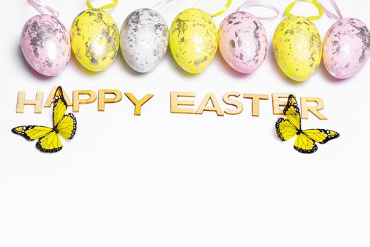 Happy Easter.Multi-colored Easter eggs on a white background with a bunch of wooden letters Happy Easter.
