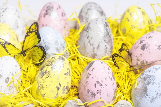 Happy Easter.Multi-colored Easter eggs on a white background with a bunch of wooden letters Happy Easter.