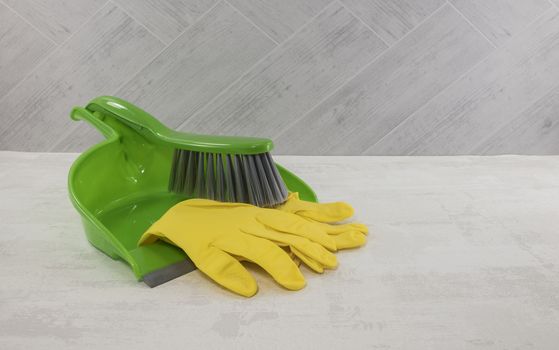 cleaning tools as dustpan and gloves in green and yellow 