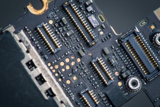 Smart phone components, circuit board of mobile cellphone, connectors, on a dark bacground.