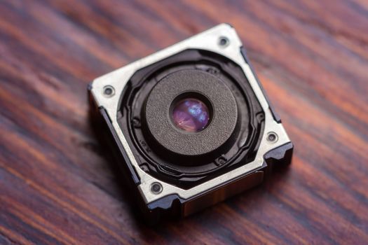 Close up of a mobile phone camera sensor on wooden background.