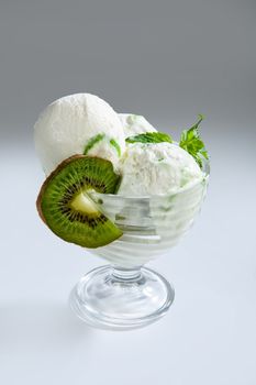 Glass with Icecream and kiwi on a studio background
