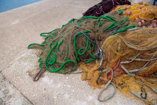 Fishing net on pier piled up, traditional net fishing concept, fishing industry, seafront still life