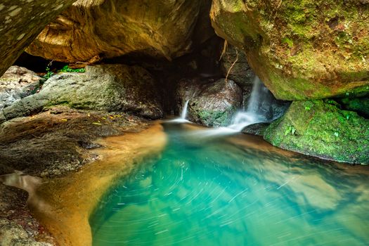 Beautiful waterfall flowing through rocky crevices into a deep pool of crystal clear water that just takes your breath away