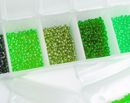 Fletley, plastic box with colorful beads for creativity and hobby, Bright sparkling beads on white background.